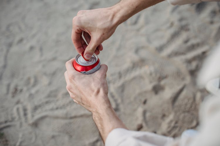 Man Opening Can Of Drink In Nature