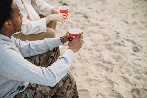Free Thoughtful black man having drink with friend Stock Photo