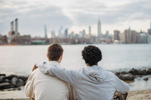 Diverse best friends hugging on embankment