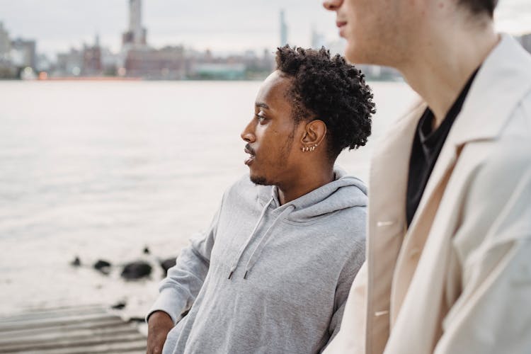 Black Man Standing On Embankment Near Friend