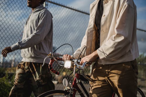 Man In Bruin Overhemd Met Knoop Omhoog En Bruine Broek Die Zich Naast Rode Fiets Bevindt