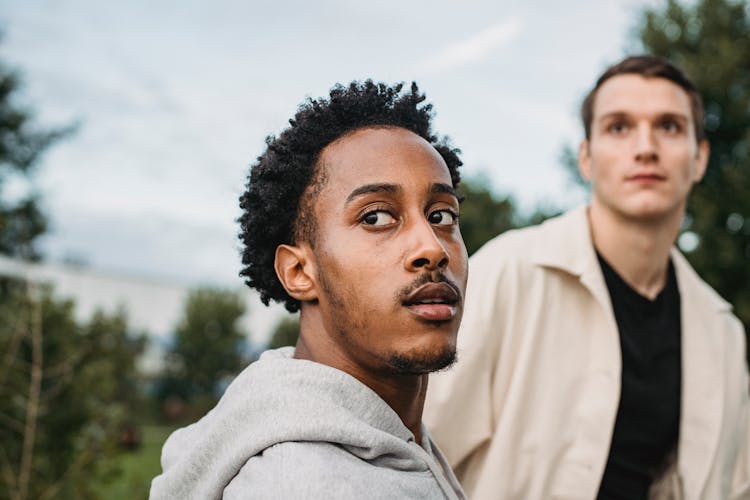 Serious Black Man Looking Over Shoulder Together With Male Friend