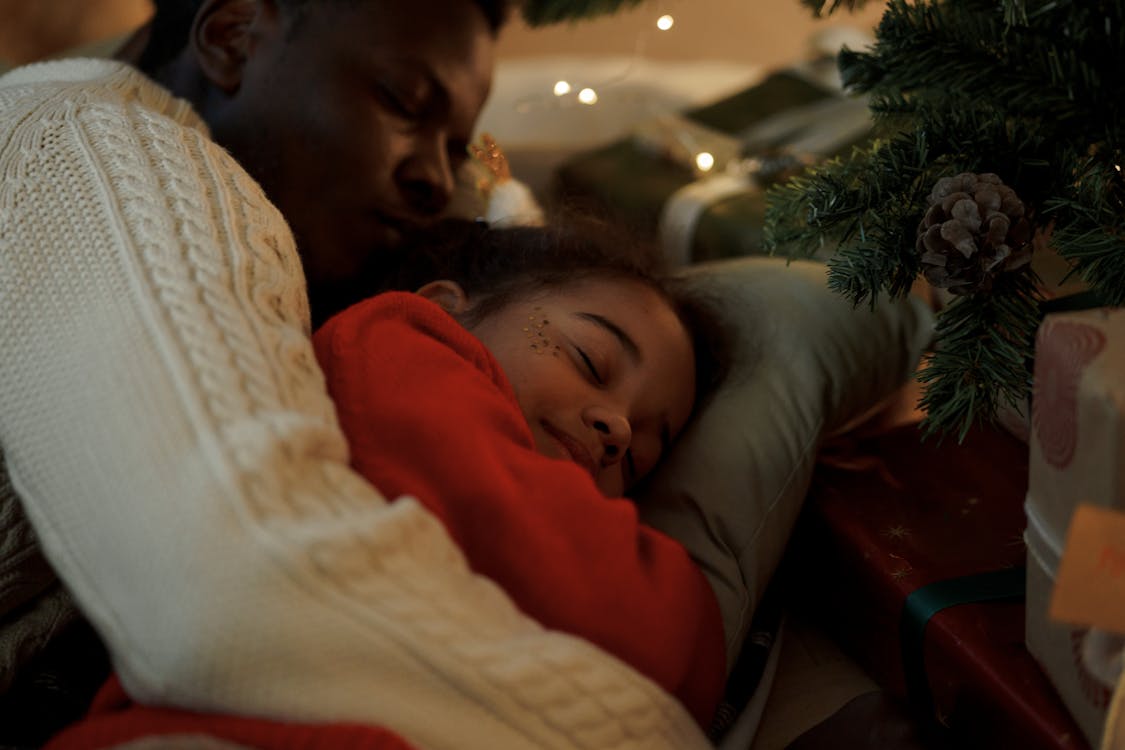 Free Dad Embracing Her Daughter While Sleeping Stock Photo