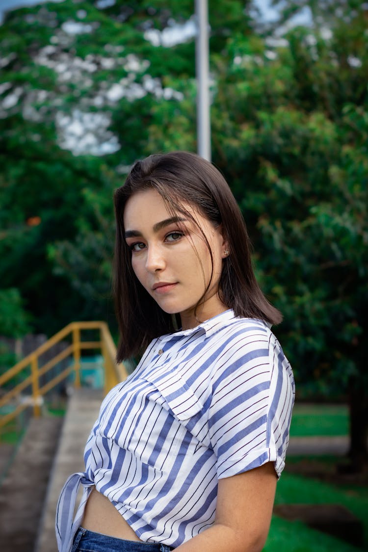 Woman In White And Blue Striped Long Sleeve Polo Posing