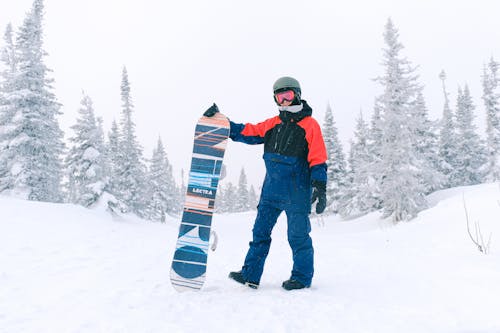 Man Wearing a Winter Jacket Holding a Snowboard