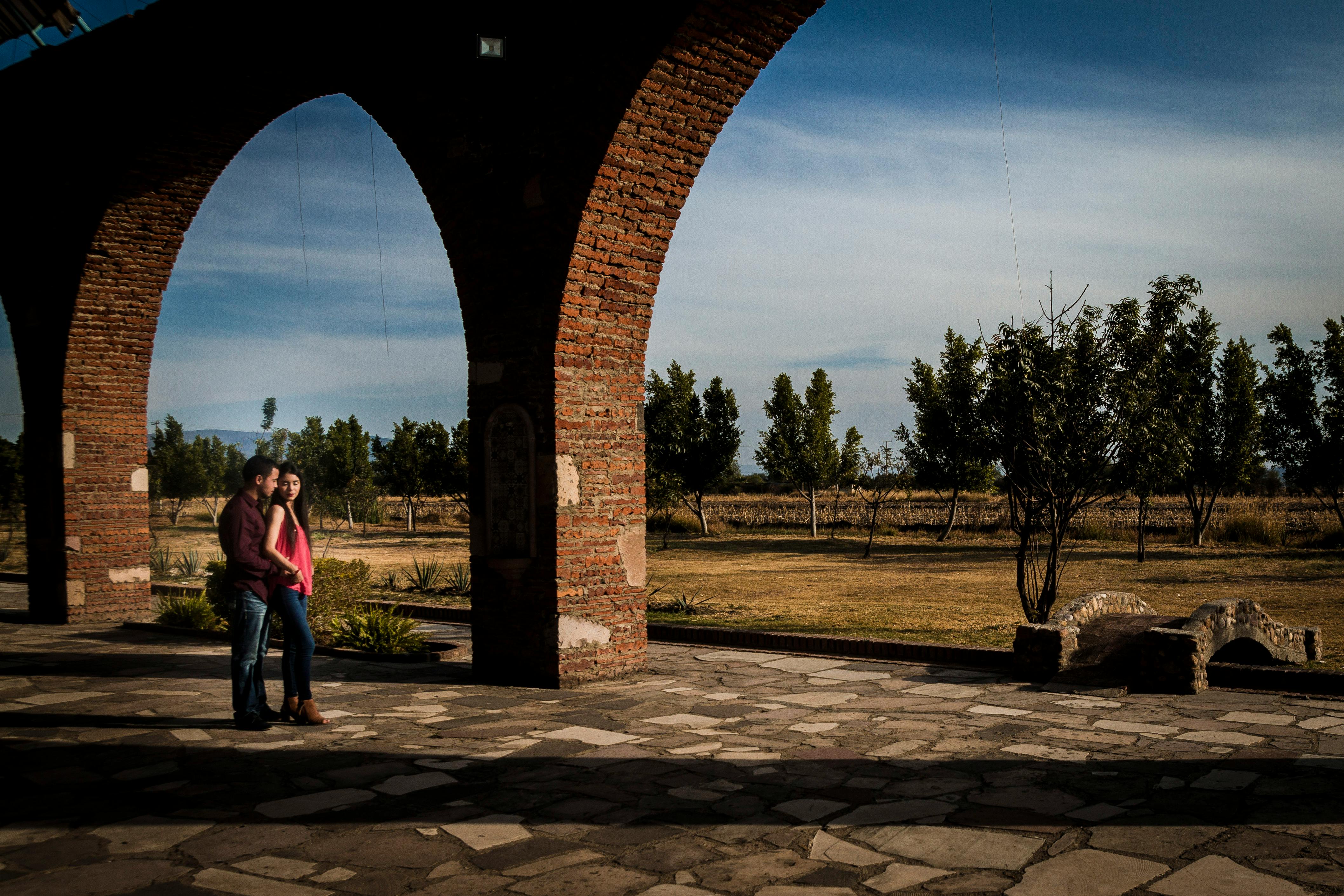 man and woman walking on brown brick pathway