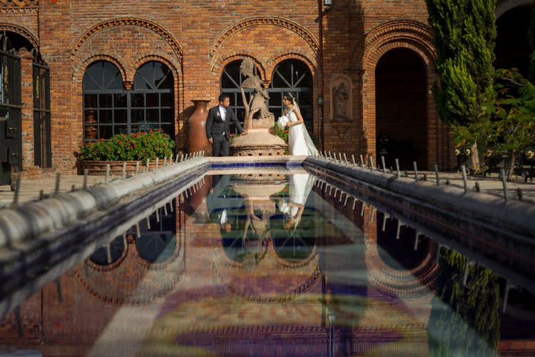 Couple Standing Near A Pool On Their Wedding Day