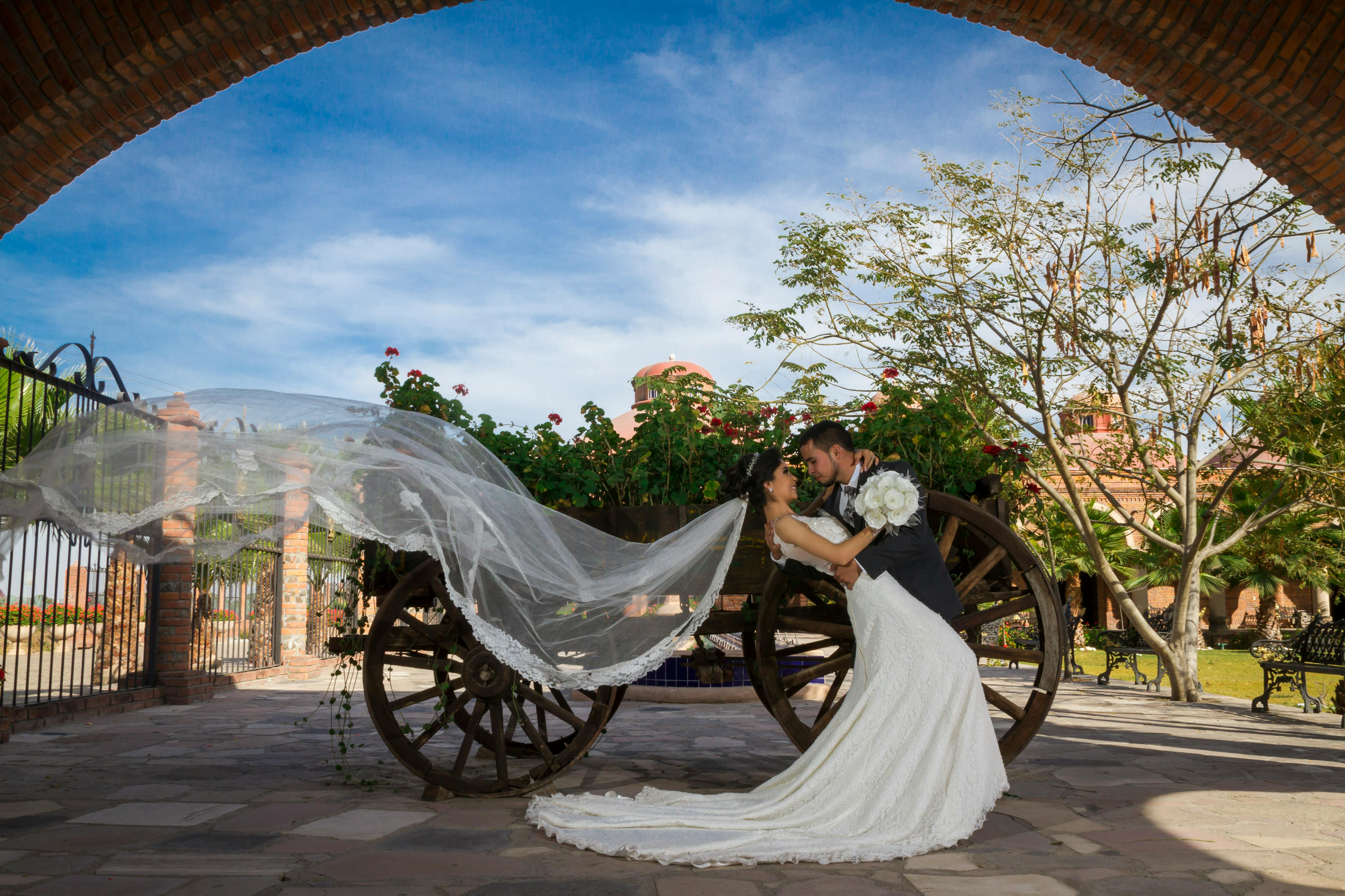 Man and Woman Hugging Beside a Wooden Carriage