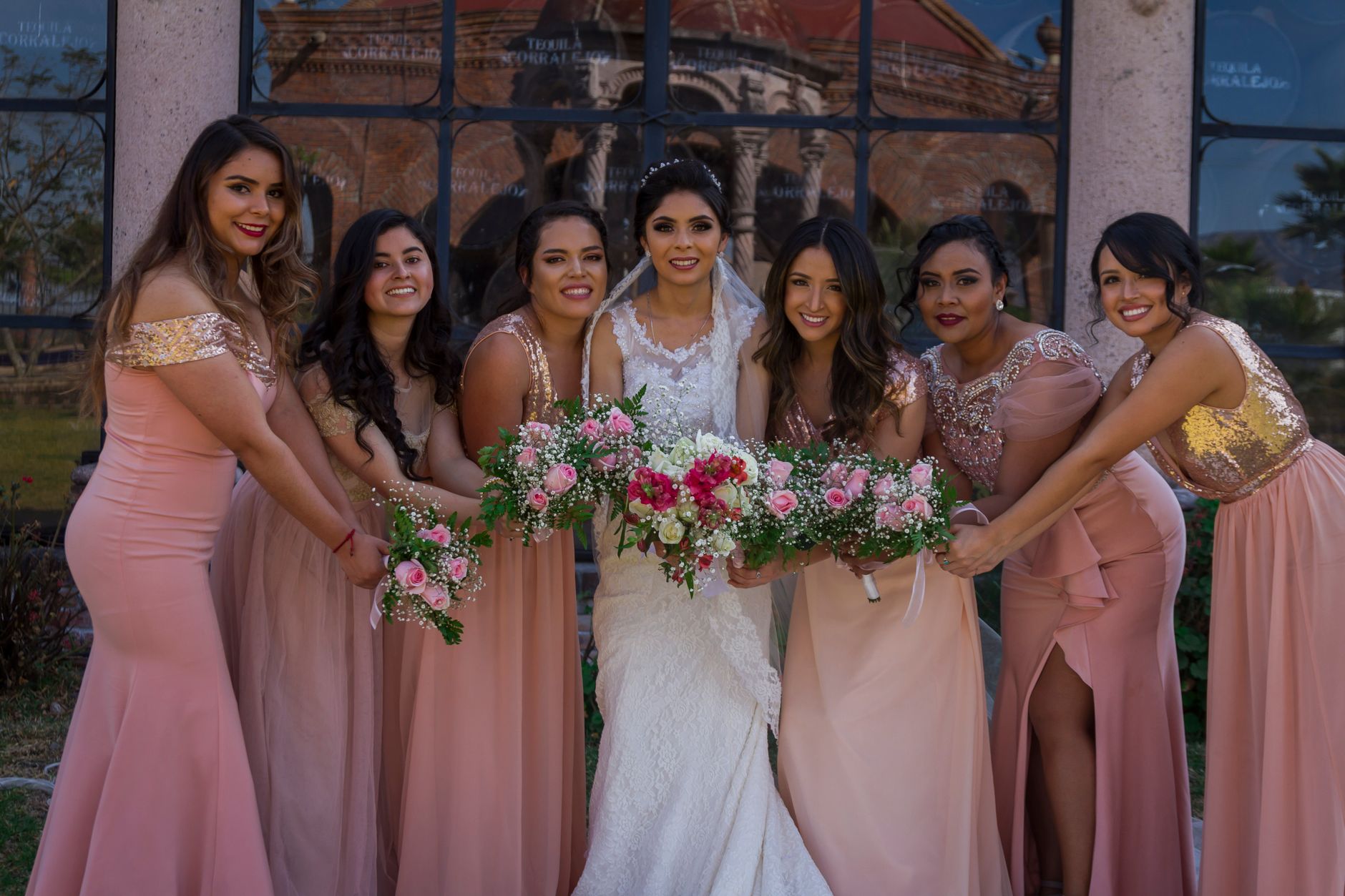 Menjaga Konsistensi Kualitas Rasa dan Standar Pelayanan Profesional untuk Setiap Acara 3 A joyful bride and her bridesmaids posing outdoors with bouquets on a sunny wedding day.