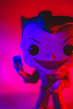 Little extraordinary toy of superhero with angry big smile in bright light on blurred background