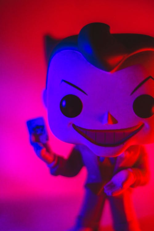 Little extraordinary toy of superhero with angry big smile in bright light on blurred background