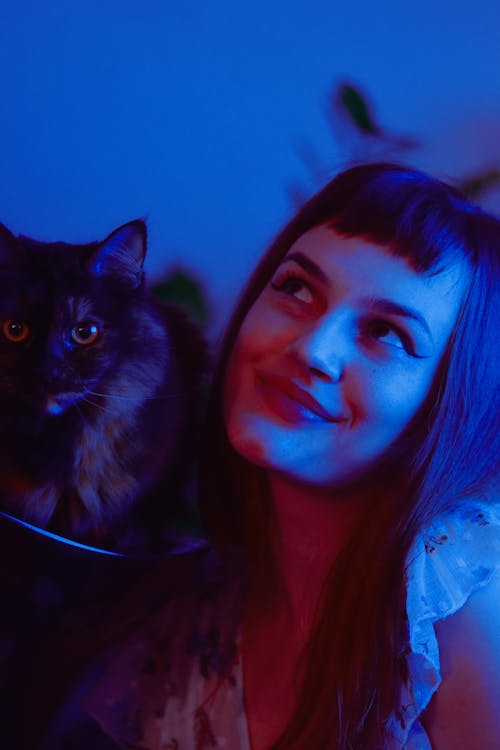 Free Woman with cat in room with neon light Stock Photo
