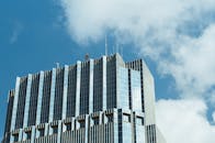 在加拿大伦敦，一座现代摩天大楼的低角度视图映衬着玻璃建筑与充满活力的蓝天