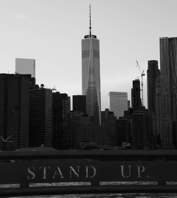 Black and white view of New York City skyline featuring the Freedom Tower at twilight.