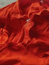 From above of stylish bright red fabric jacket with zipper and pockets on chest