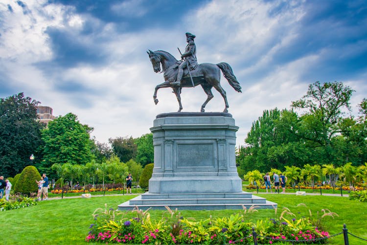 Man Riding Horse Statue Under White Clouds