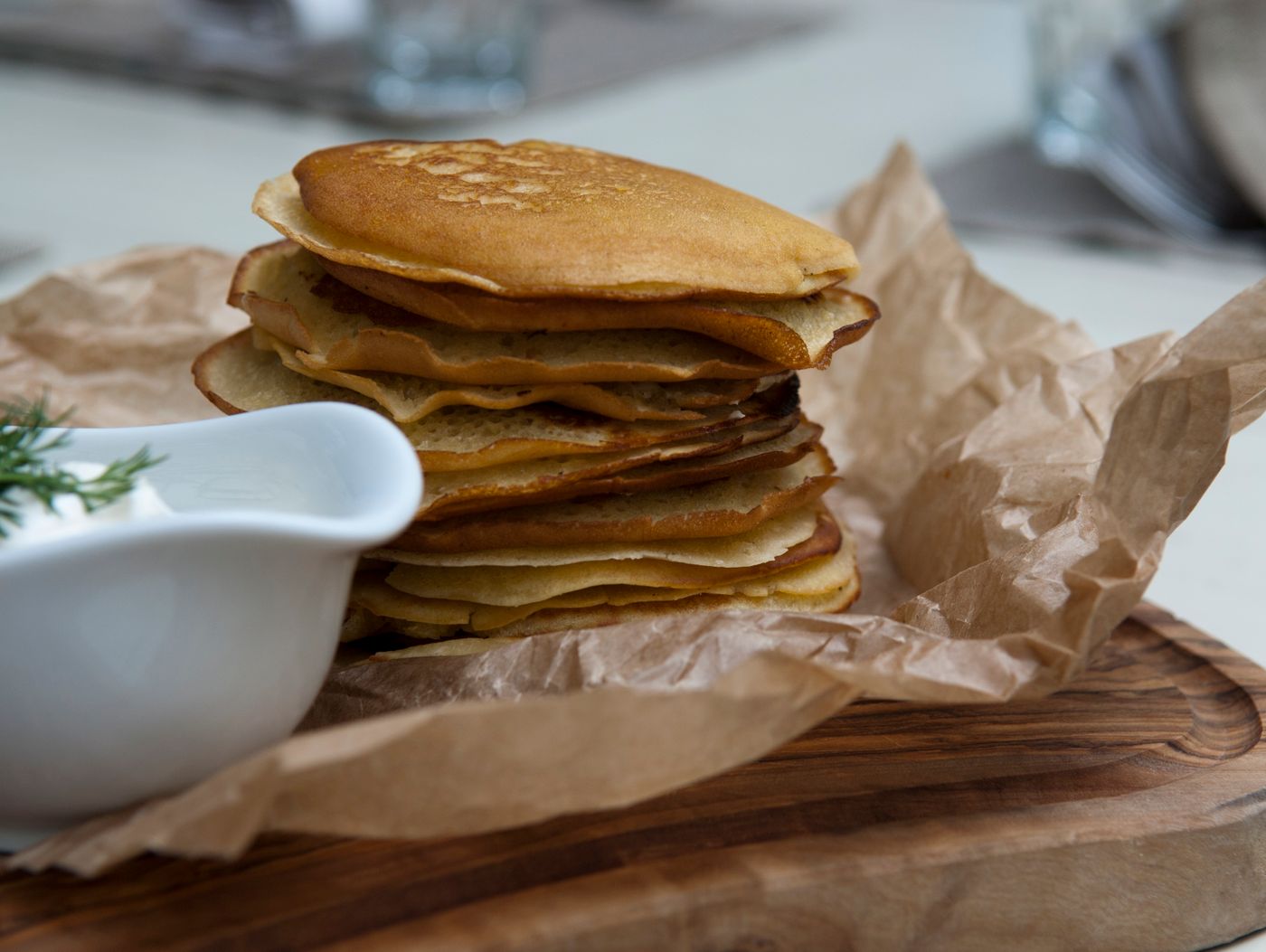 A delicious stack of homemade pancakes served on a rustic wooden board, perfect for breakfast.
