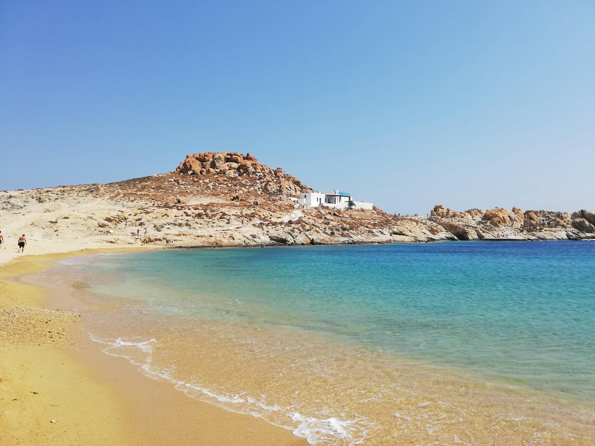 Enjoy the tranquil beauty of Sarakiniko Beach on Milos Island, Greece, with clear blue waters and golden sands.