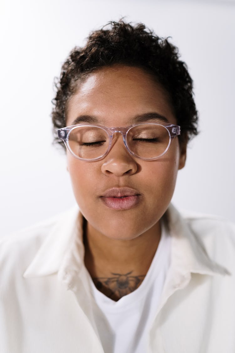 Young Curly Woman In White Shirt And Eyeglasses