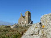 Old observation tower or rocky hill under bright blue sky