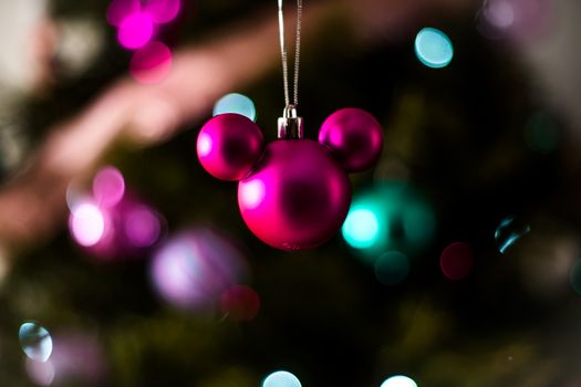 Close-up of a magenta Christmas ornament with a bokeh background, creating a festive winter mood.