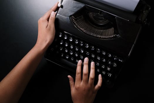 Close-up of hands typing on a classic Russian typewriter, highlighting the retro feel of writing.