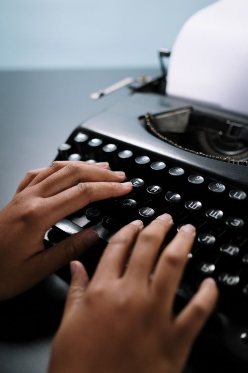 Free Hands typing on a classic black typewriter, emphasizing retro technology. Stock Photo