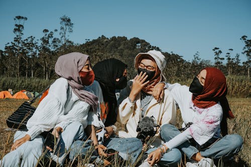 Free Muslim friends resting in countryside together at weekend Stock Photo