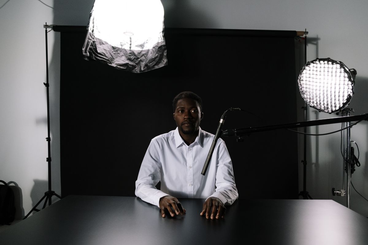 Photo by cottonbro studio on Pexels — a speaker seated at a table under studio lights