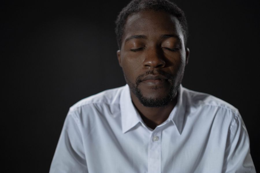 Instructor with eyes closed in a dark studio — photo by cottonbro studio on Pexels