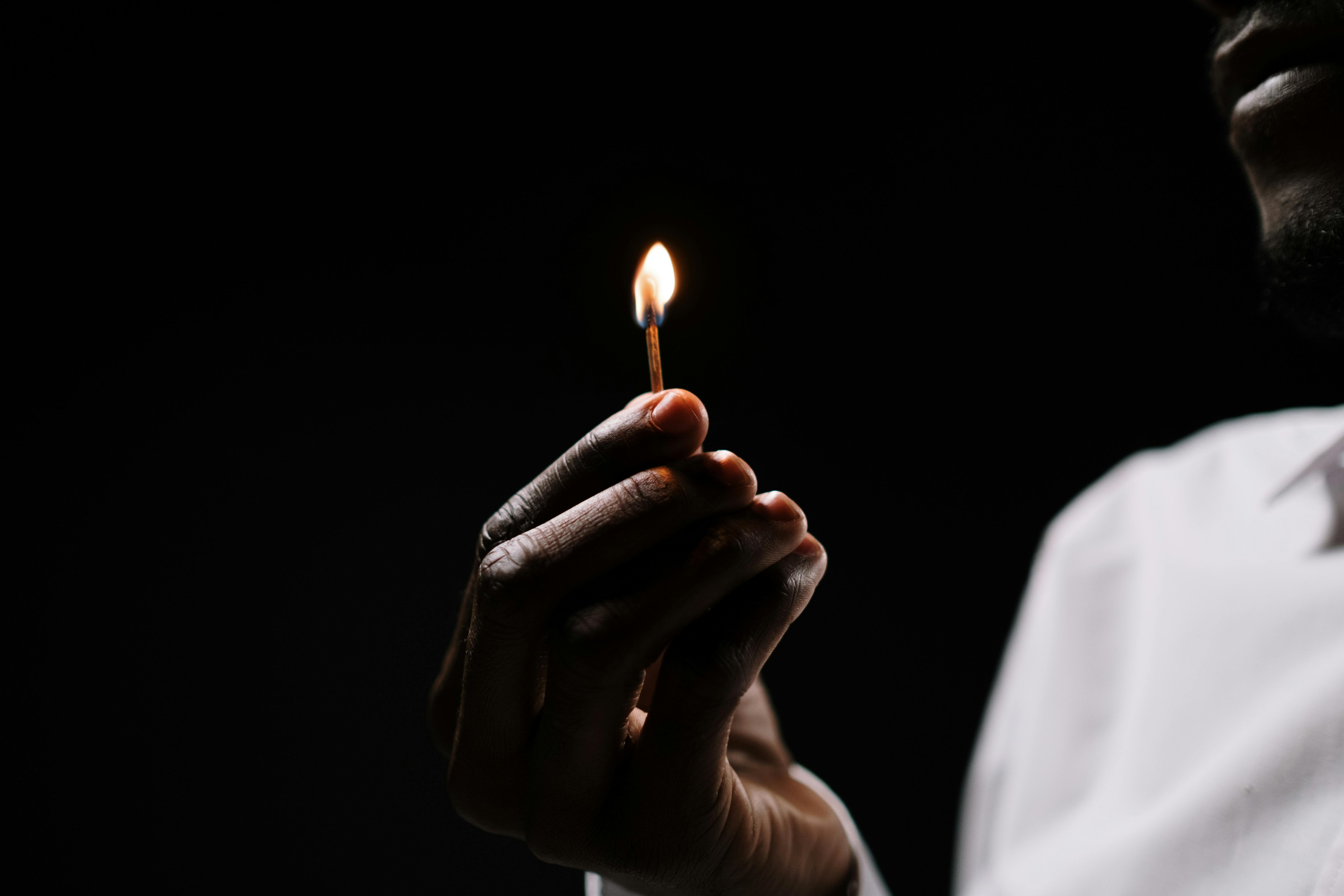 Person Holding Lighted Candle in Dark Room · Free Stock Photo