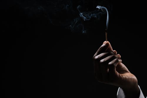 Orang Yang Memegang Tongkat Rokok Yang Menyala