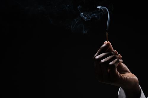 Free A hand holds a lightly smoking match against a dark background, capturing a dramatic and moody feel. Stock Photo