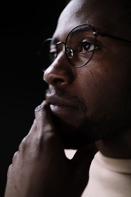 Close-Up Shot of a Man with Eyeglasses Thinking