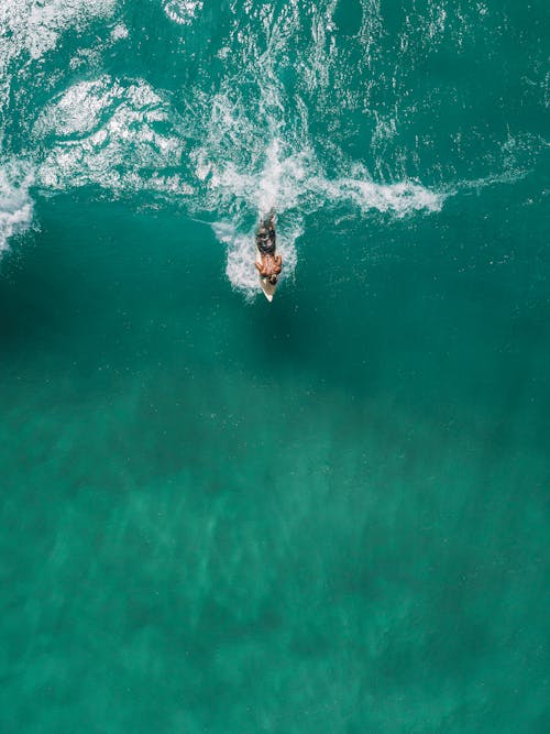 緑の水でサーフィンする人