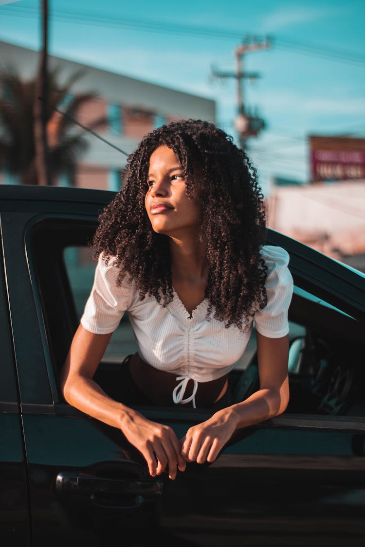 Confident Black Woman Hanging Out Of Window Car In Sunlight