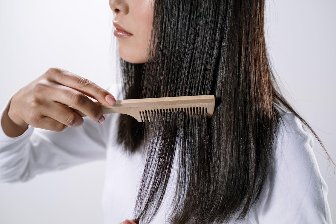 Free Woman Holding Brown Wooden Hair Comb Stock Photo
