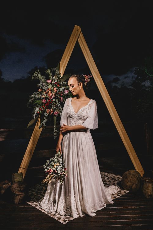 Free Young mindful woman in bridal dress with closed eyes standing with flower bouquet during festive event in twilight Stock Photo