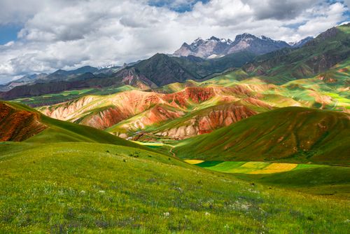 Free Stunning mountain landscape showcasing colorful hills and valleys under a cloudy sky. Stock Photo