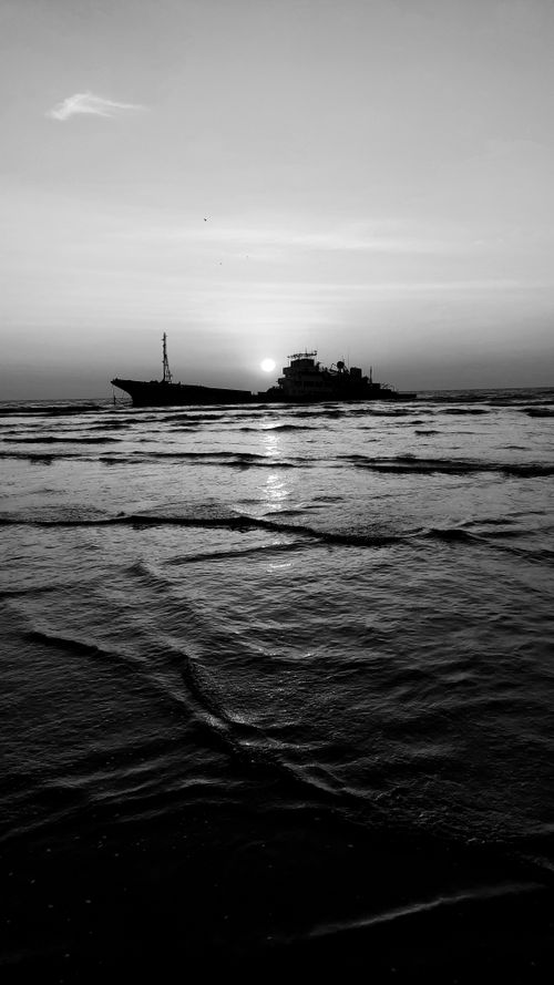 Free Black and white image of a ship at sunrise over the Indian Ocean, Kerala. Stock Photo