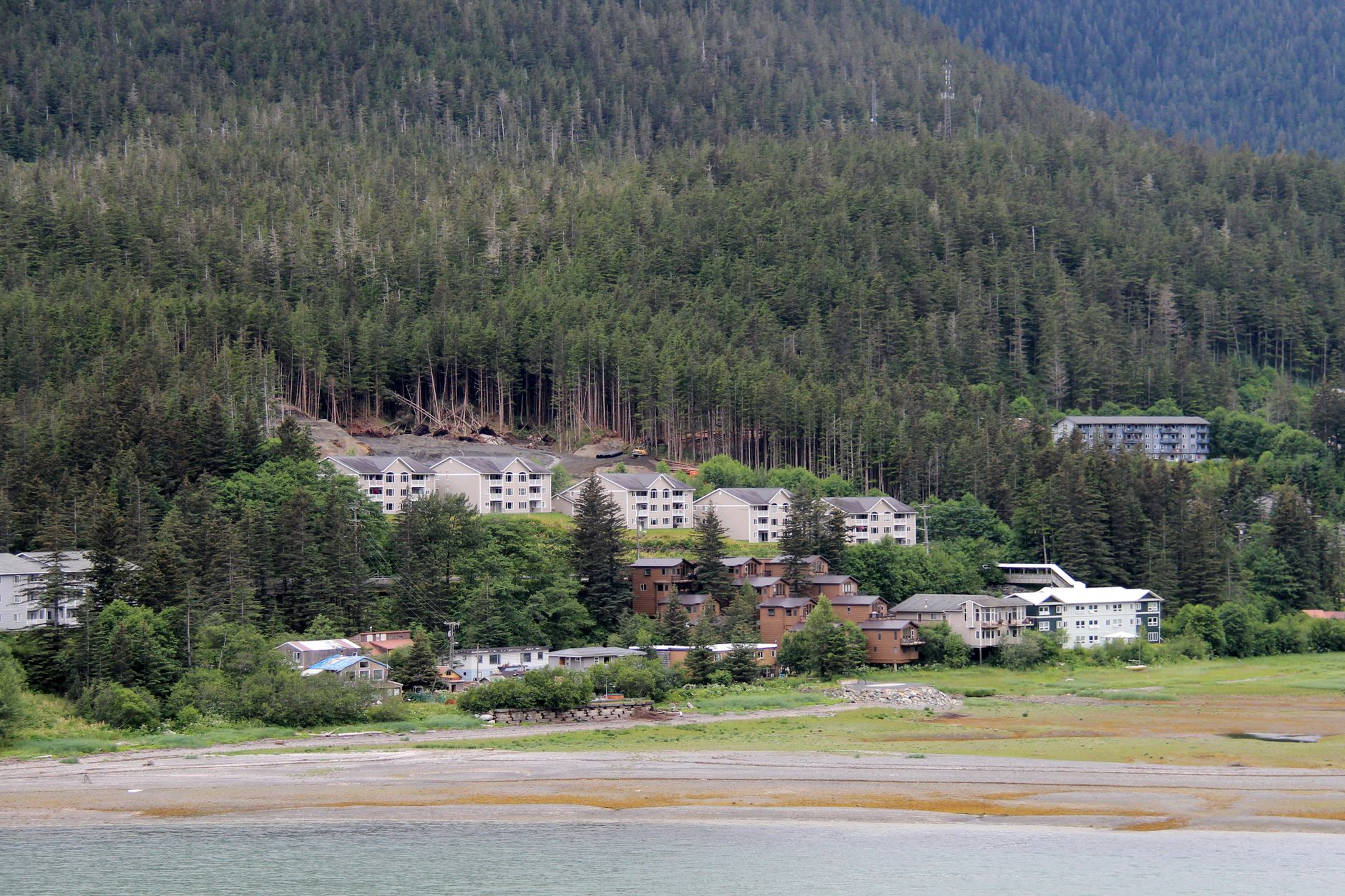 A tranquil Alaskan town nestled by the forest and water, showcasing nature and architecture.