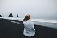 在冰岛埃斯菲亚拉海滩，一名女子凝视着戏剧性地展开的海斯特