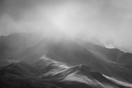 Dramatic black and white photo of misty mountains in Georgia. Ideal for nature and travel themes.