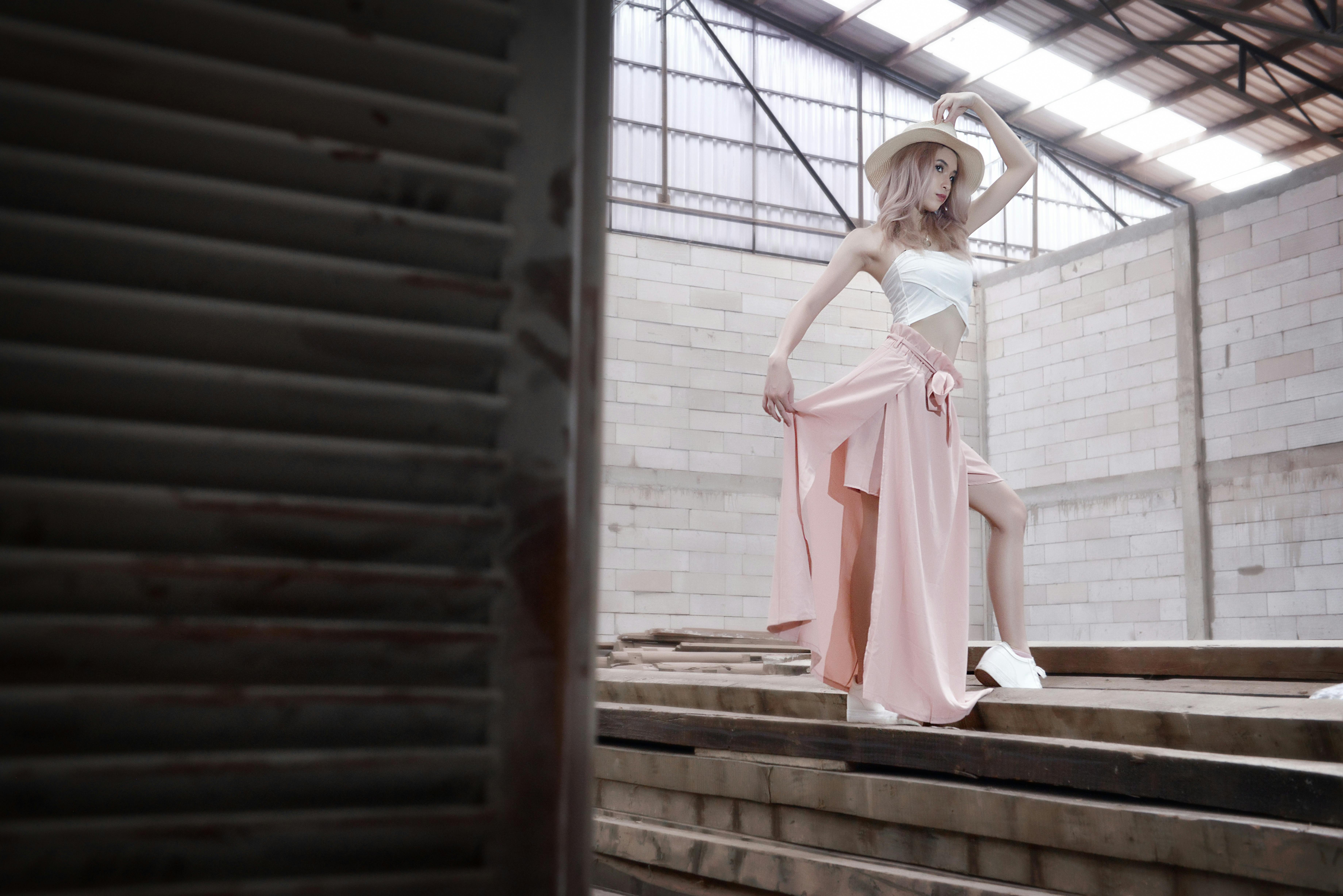 Model in pink skirt and hat posing inside an industrial building in Phnom Penh.
