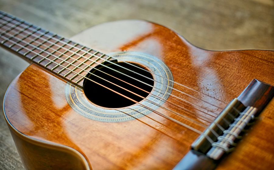Gros plan sur les cordes et la table d'une guitare acoustique