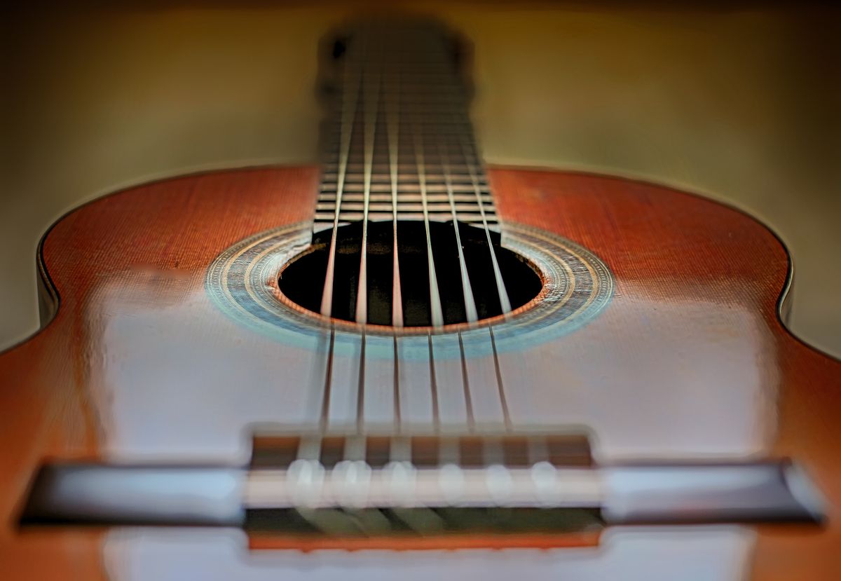Close-up of acoustic guitar strings and soundhole, representing instrument gifts for practicing musicians