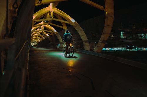 Free A cyclist rides through the illuminated Puente de Luz in Toronto, Ontario at night. Stock Photo