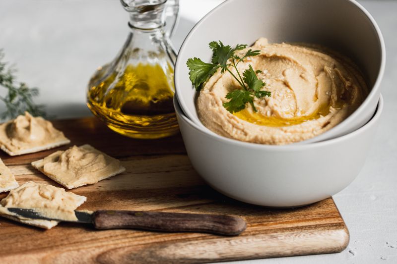 cheese and crackers plate with a small bowl of hummus