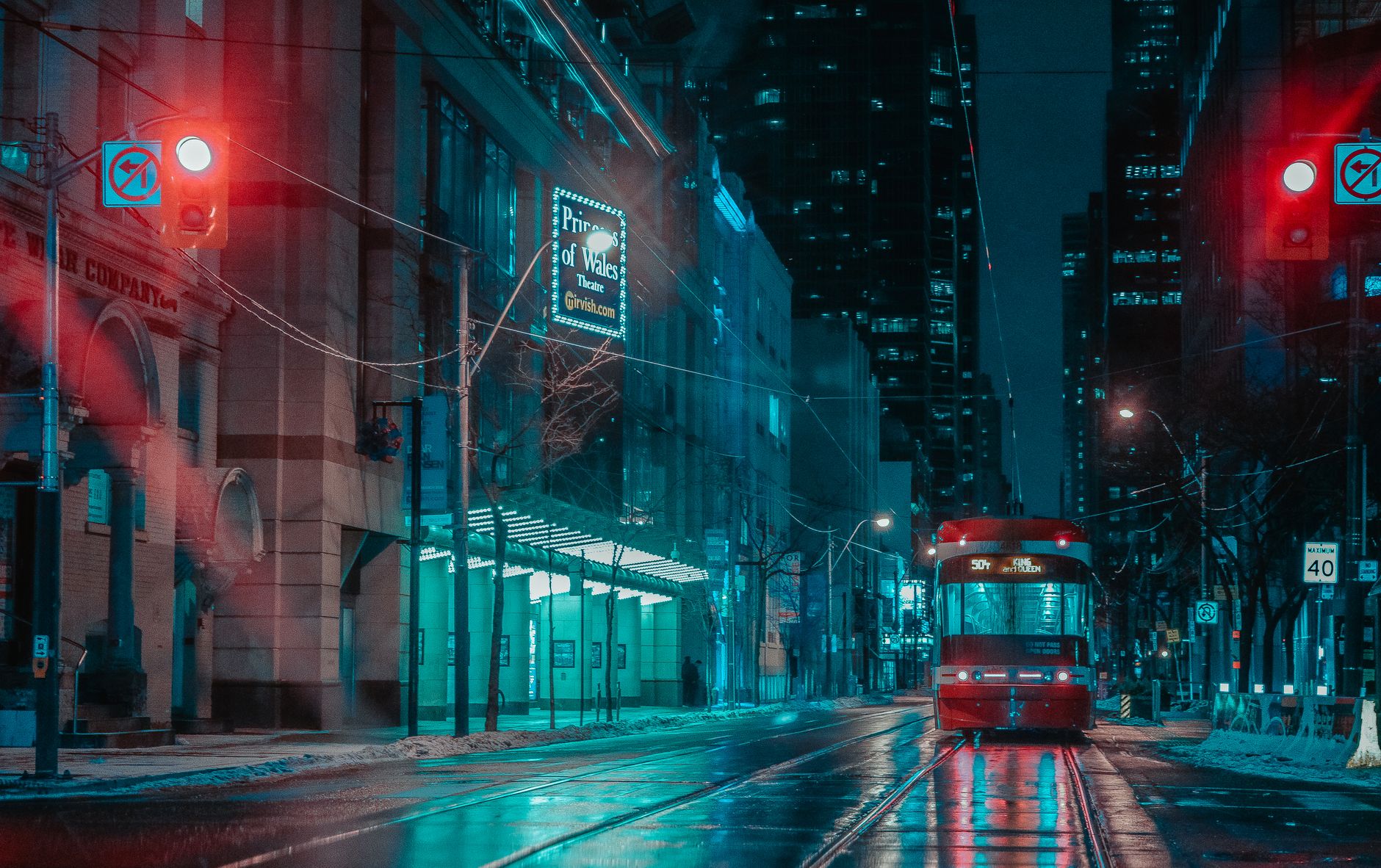 Moody nighttime view of a streetcar on a rainy street in downtown Toronto, Canada.