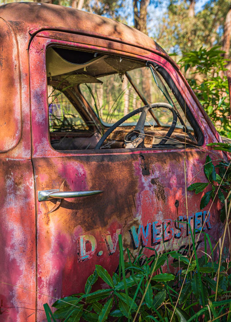 An Abandoned Car Parked On The Field